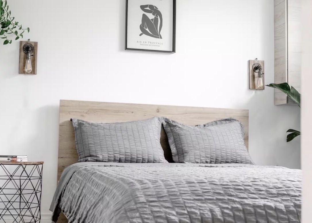 Bedroom with wood headboard and grey linens